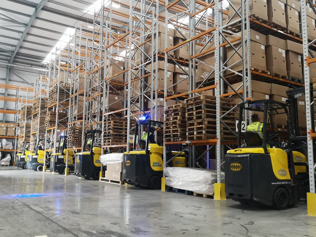 HSL Chairs - 6 forklift trucks lined up between warehouse storage units